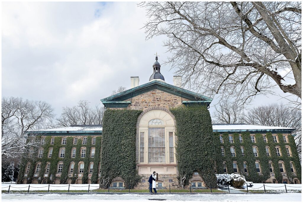 Winter engagement session at Princeton University with sparkling snow flurries and a couple in classic overcoats.